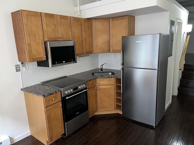 12 Stoneholm St Unit 313, Boston, MA 02115 - kitchen with appliances with stainless steel finishes, a sink, dark wood-style floors, dark stone countertops, and brown cabinetry