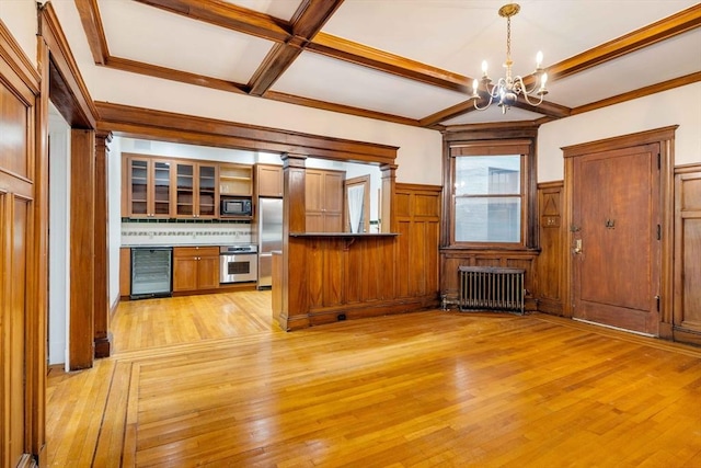 345 Commonwealth Ave Unit 3, Boston, MA 02115 - kitchen with radiator, appliances with stainless steel finishes, wine cooler, a chandelier, and light wood-style flooring