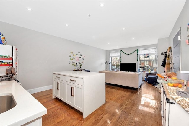 kitchen with recessed lighting, light wood-type flooring, white cabinets, and light countertops