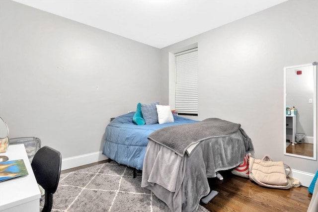 bedroom with wood finished floors and baseboards