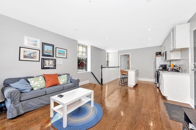 living area featuring recessed lighting, baseboards, and wood finished floors