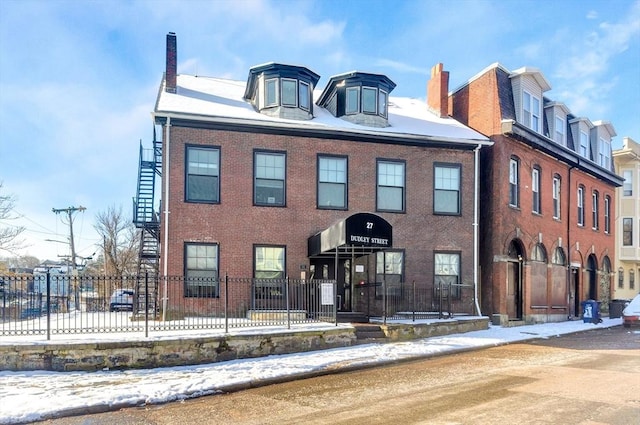 view of front of house with fence and brick siding