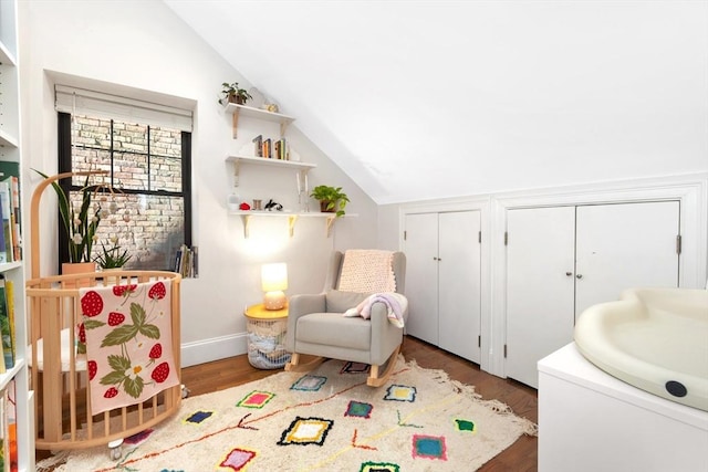 interior space with baseboards, lofted ceiling, and wood finished floors