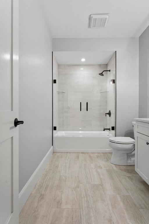 full bathroom featuring tile flooring, toilet, vanity, and tiled shower / bath