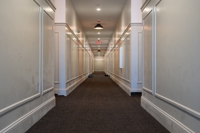 hall with dark colored carpet