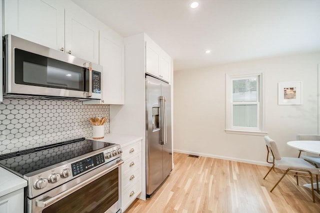 kitchen featuring stainless steel appliances, light countertops, light wood-style flooring, and recessed lighting