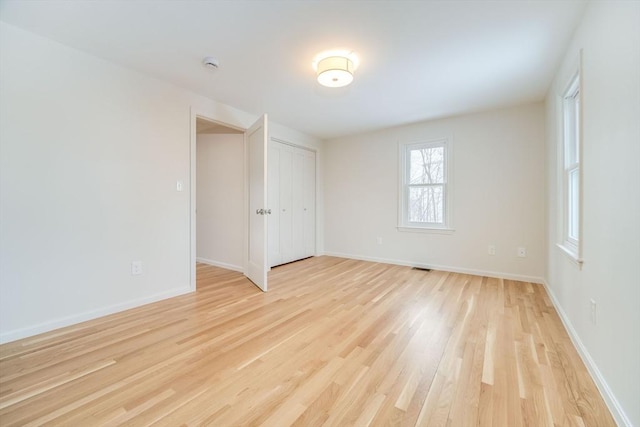 spare room featuring light wood-style flooring, baseboards, and a smoke detector