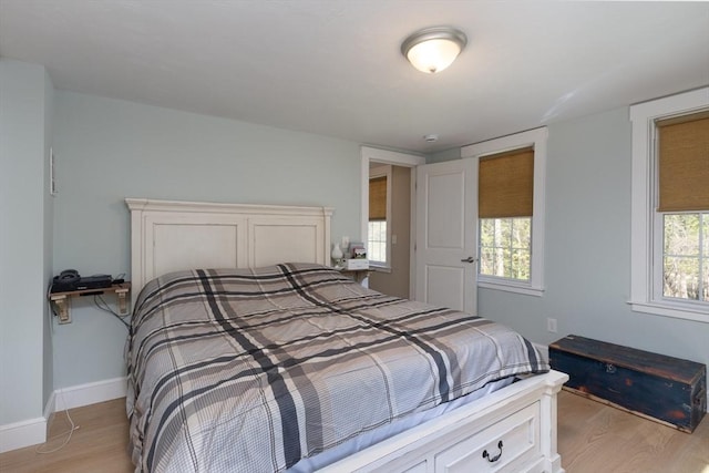 bedroom with light wood-type flooring and baseboards