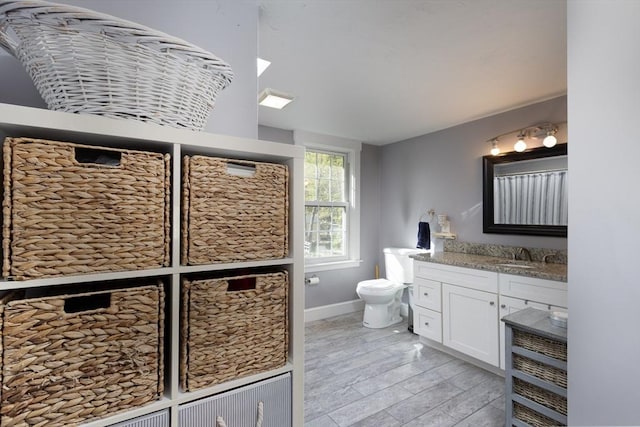 full bathroom with vanity, toilet, and baseboards