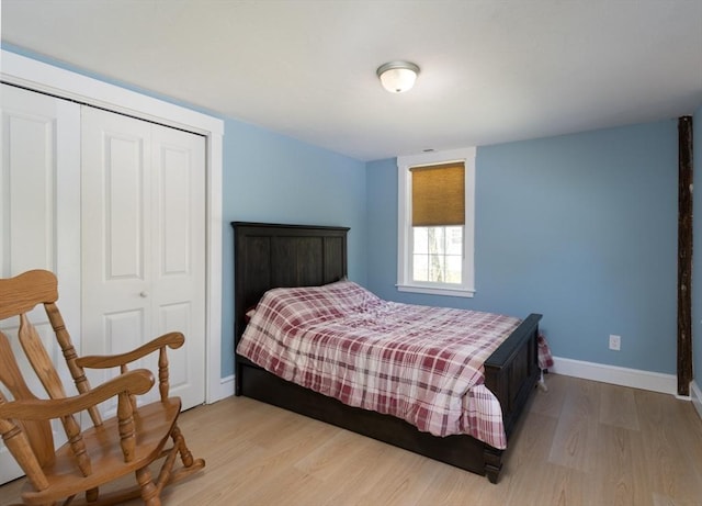 bedroom featuring baseboards, a closet, and light wood-style flooring