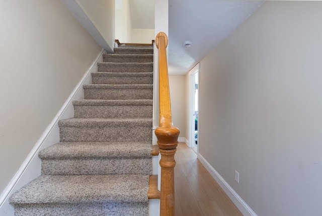 stairs with wood finished floors and baseboards
