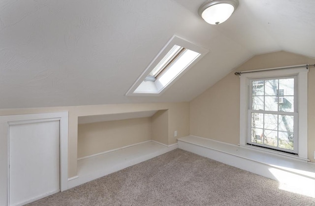 additional living space with carpet floors and vaulted ceiling with skylight