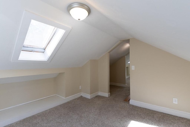 bonus room with lofted ceiling with skylight, carpet floors, and baseboards