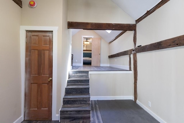 stairway with baseboards and vaulted ceiling with beams
