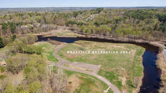 drone / aerial view featuring a wooded view and a water view