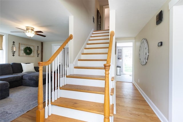 stairs with baseboards, a ceiling fan, visible vents, and wood finished floors