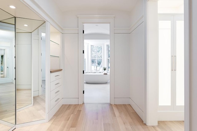 hall with light wood finished floors and recessed lighting