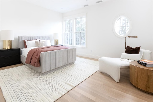 bedroom with visible vents, light wood-style flooring, and baseboards