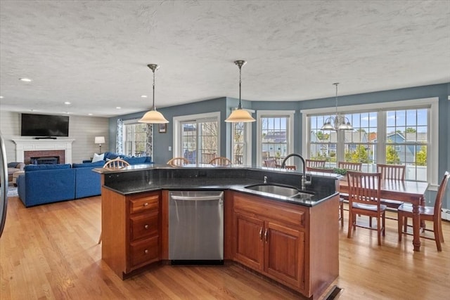kitchen with a sink, light wood finished floors, dishwasher, a textured ceiling, and brown cabinetry