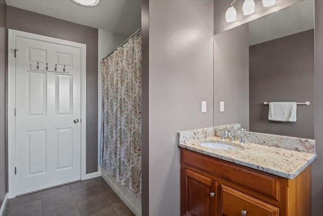 bathroom with tile patterned flooring, baseboards, and vanity