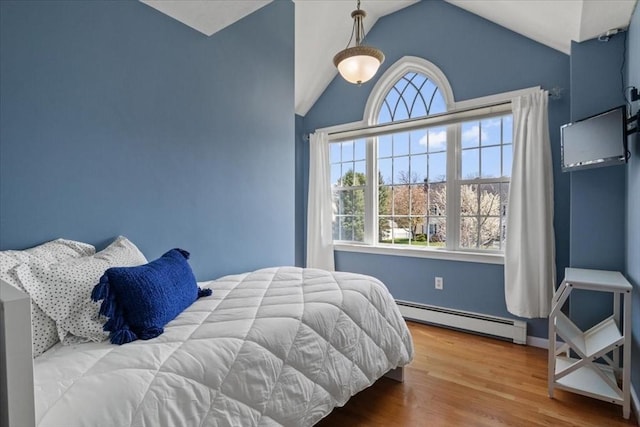 bedroom with a baseboard radiator, vaulted ceiling, and wood finished floors