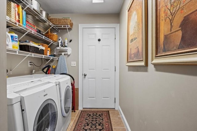 laundry area featuring light tile patterned floors, separate washer and dryer, baseboards, and laundry area