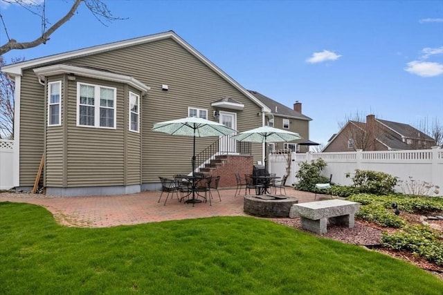 rear view of house featuring a patio area, fence, and a yard