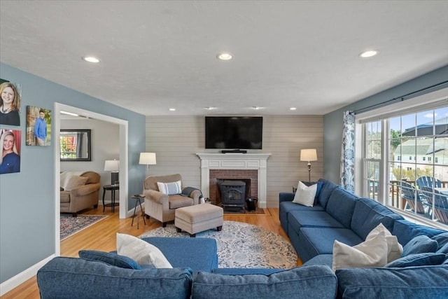living area featuring recessed lighting, baseboards, an accent wall, and light wood finished floors