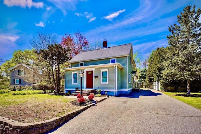 bungalow-style house featuring driveway and a chimney