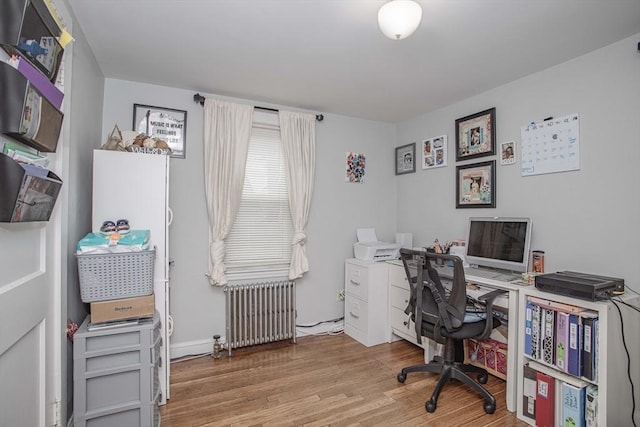 home office featuring wood finished floors and radiator