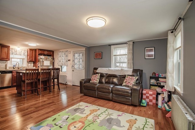 living area with radiator and wood finished floors