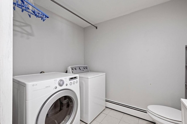 clothes washing area featuring independent washer and dryer, baseboard heating, and laundry area