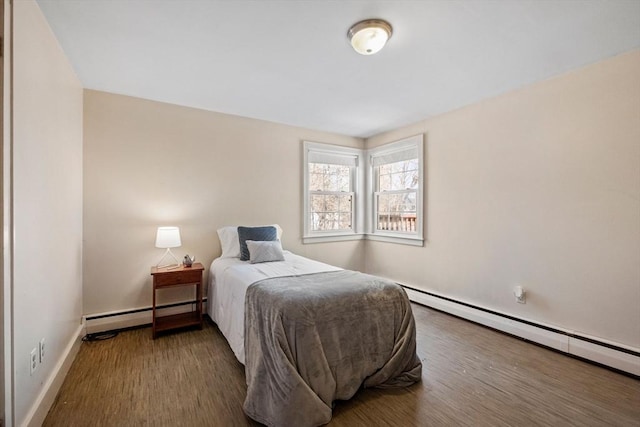bedroom featuring a baseboard radiator, wood finished floors, and baseboards