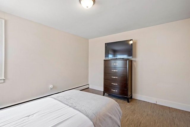 bedroom featuring wood finished floors and baseboards