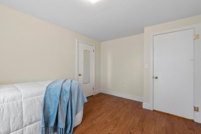 bedroom with baseboards and wood finished floors
