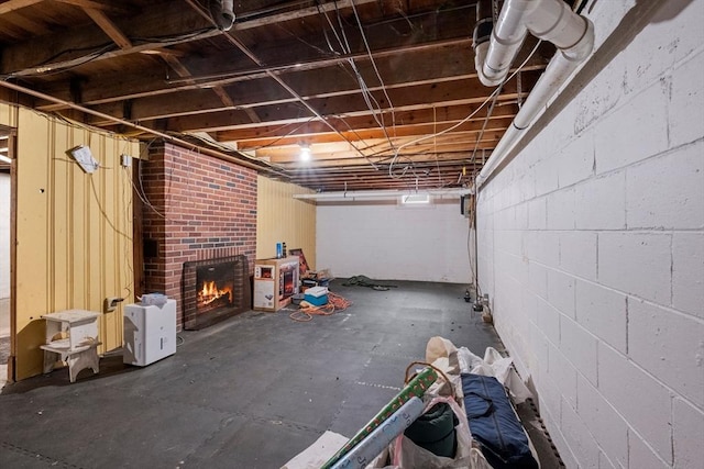 unfinished below grade area with a brick fireplace and concrete block wall