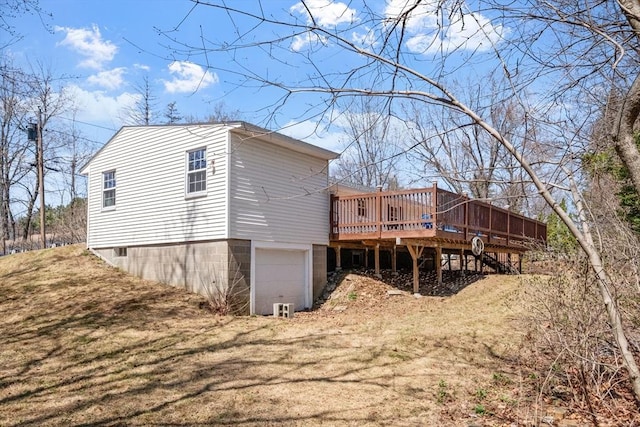 back of house with a wooden deck and a garage