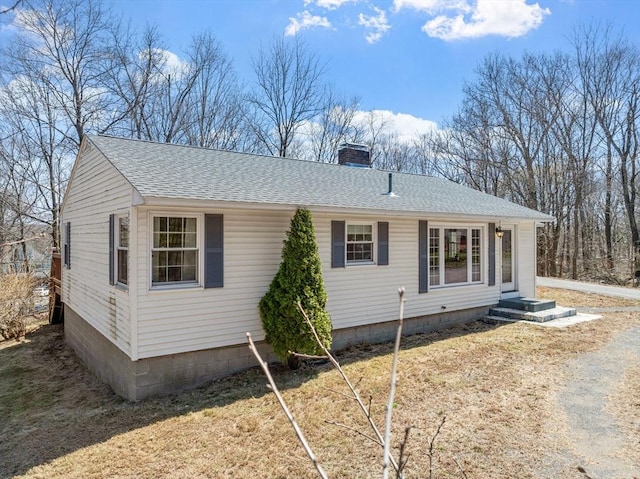 exterior space with a chimney and a shingled roof