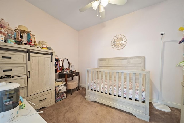 bedroom with light carpet, ceiling fan, and a crib