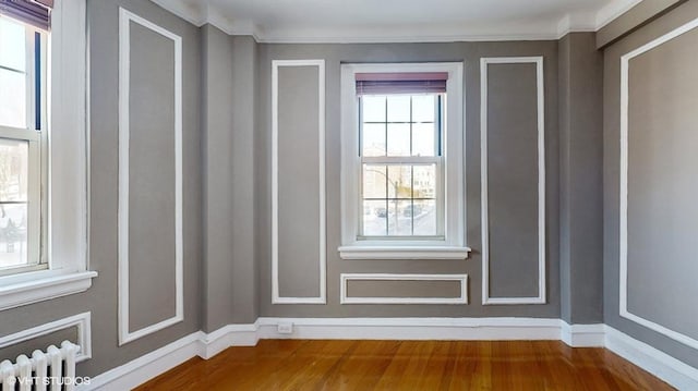 doorway featuring crown molding, hardwood / wood-style flooring, and radiator heating unit