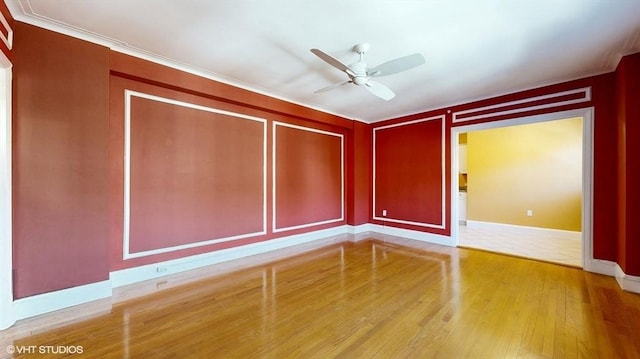 empty room featuring wood-type flooring, ornamental molding, and ceiling fan