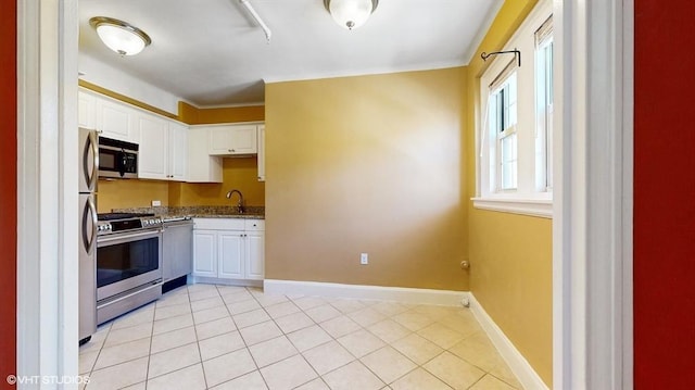 kitchen featuring white cabinetry, stainless steel appliances, sink, and dark stone countertops