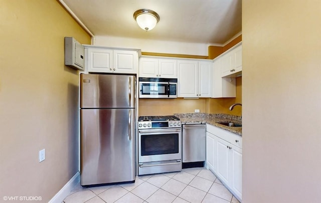 kitchen featuring white cabinetry, appliances with stainless steel finishes, sink, and dark stone counters