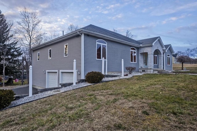 view of side of home with a lawn and a garage