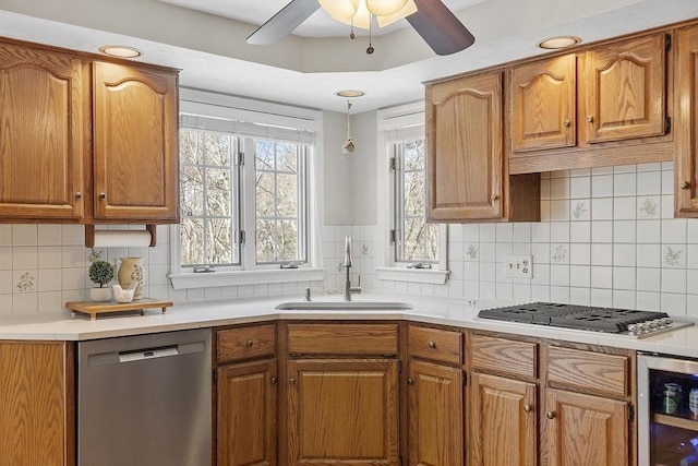 kitchen featuring beverage cooler, brown cabinets, stainless steel appliances, and a sink