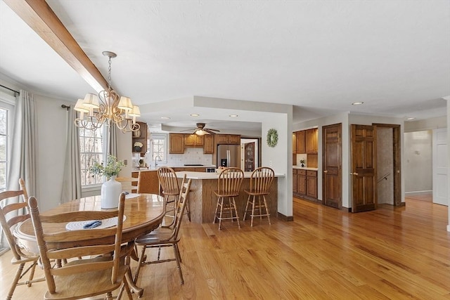 dining area with light wood-style flooring, plenty of natural light, and a chandelier