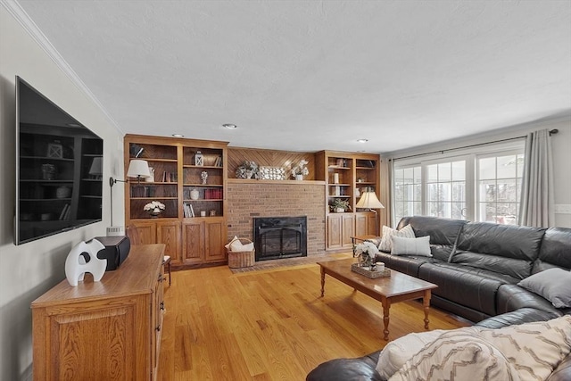 living area with light wood finished floors, built in features, a brick fireplace, and ornamental molding