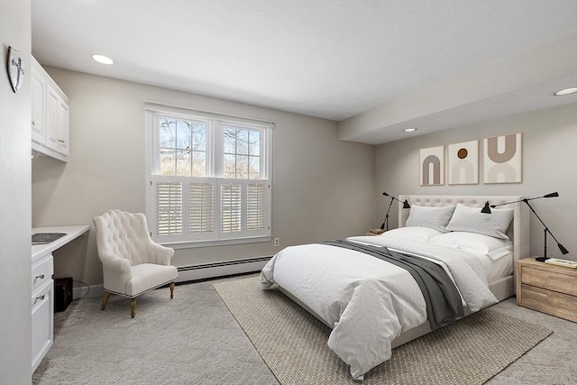 bedroom featuring a baseboard heating unit, recessed lighting, baseboards, and light carpet