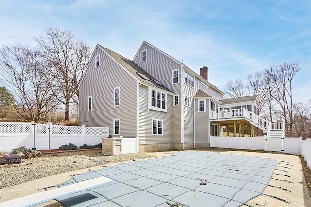 back of house featuring a fenced in pool, stairway, a fenced backyard, a patio area, and a gate