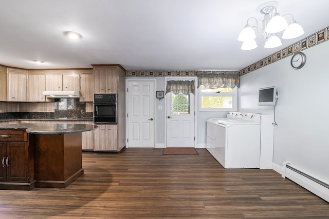 kitchen with oven, a baseboard heating unit, dark hardwood / wood-style flooring, washer and dryer, and decorative light fixtures